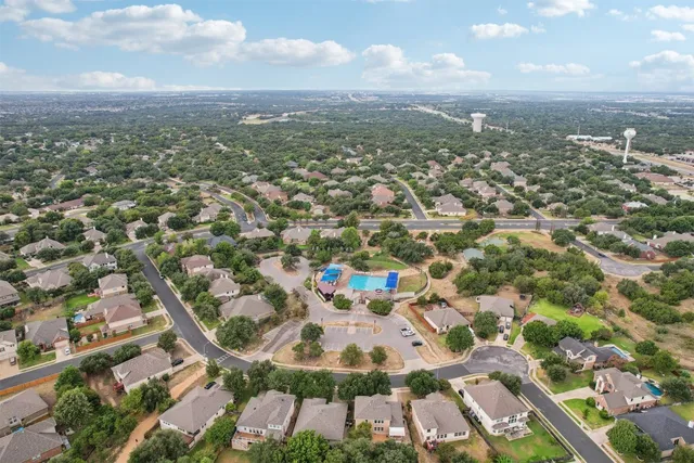 a view of a swimming pool with a bench and trees around