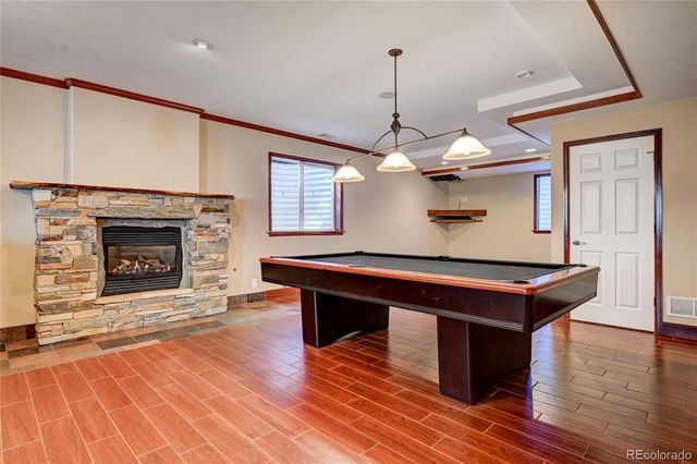 a room with pool table and wooden floor