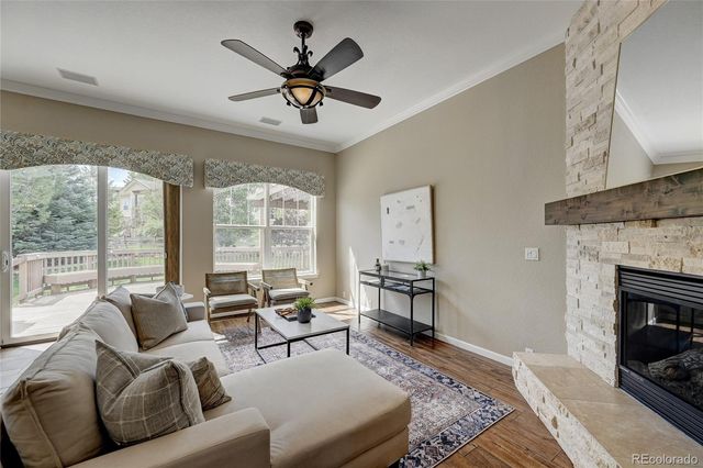 a living room with furniture ceiling fan and a fireplace
