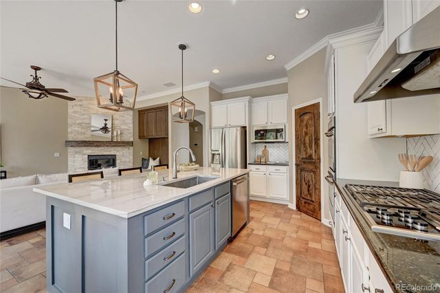 a kitchen with a sink a stove a refrigerator and chairs