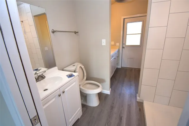 a white toilet sitting next to a sink and vanity
