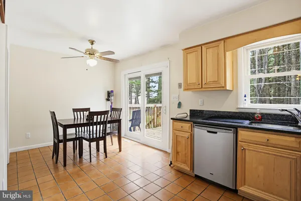 a kitchen with stainless steel appliances granite countertop a stove a sink a dining table and chairs
