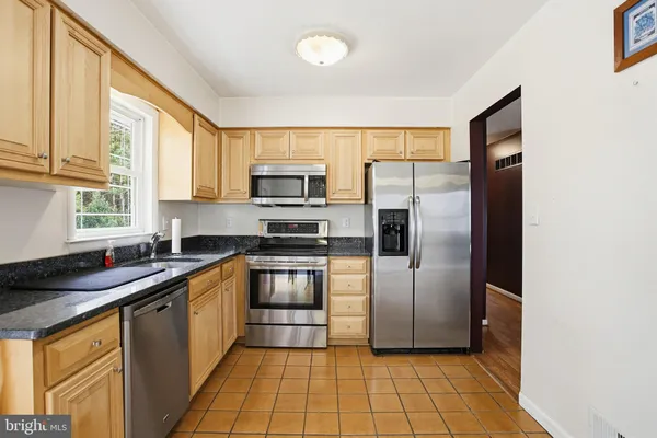 a kitchen with a sink a counter top space cabinets and stainless steel appliances