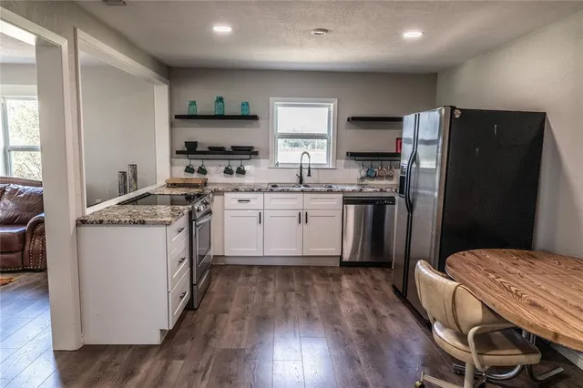 a kitchen with a sink a stove a refrigerator and black cabinets