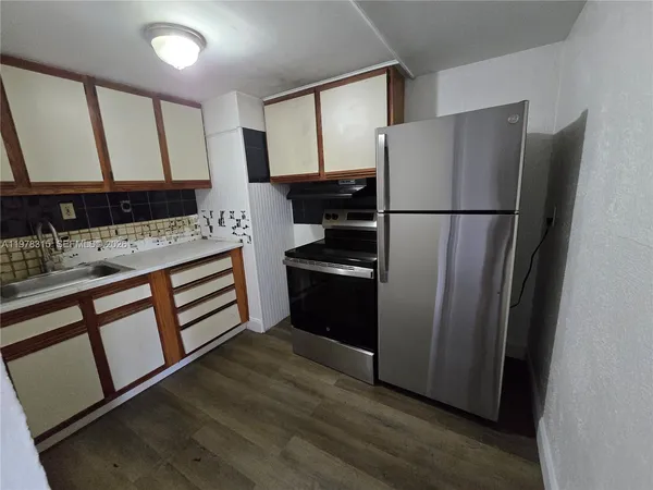 a kitchen with a refrigerator sink and cabinets