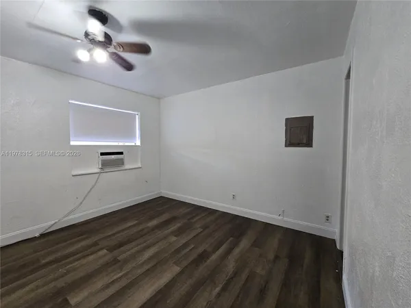 a view of room with hardwood floor and a ceiling fan
