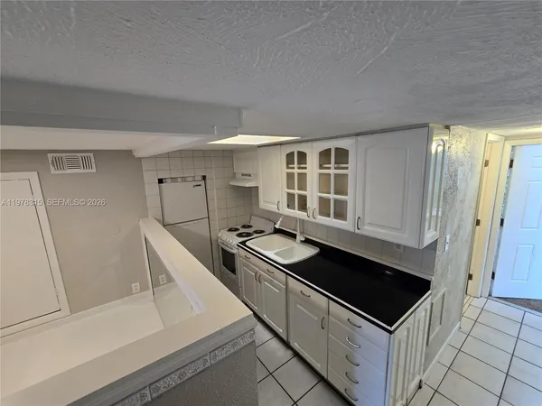 a kitchen with granite countertop a stove and a sink