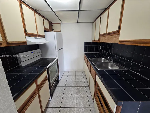 a kitchen with a sink a stove and a refrigerator