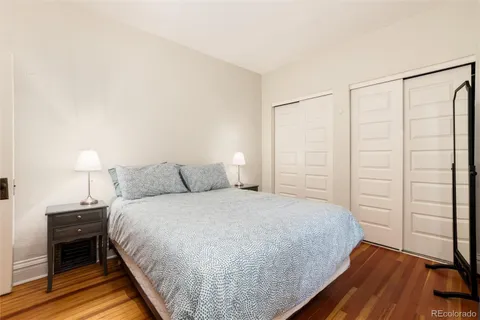 a bedroom with a bed lamp and a large window