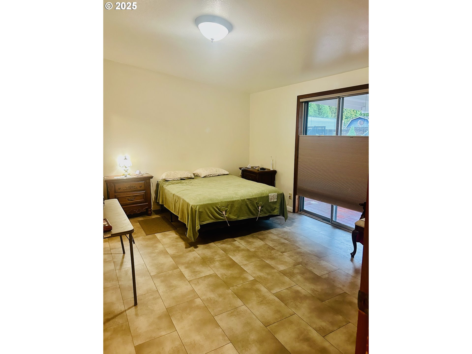 503 Southeast Sheridan Road, Unit 8 Sheridan, OR 97378 - Photo 16 of 38 a bedroom with a bed and lamp next to a window