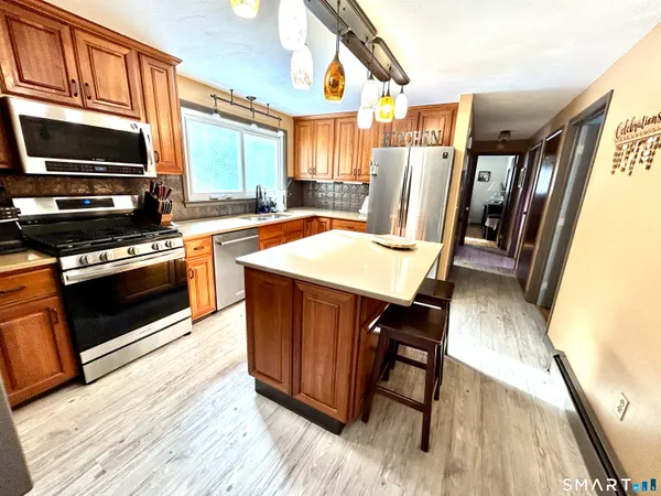 a kitchen with stainless steel appliances wooden floors and wooden cabinets