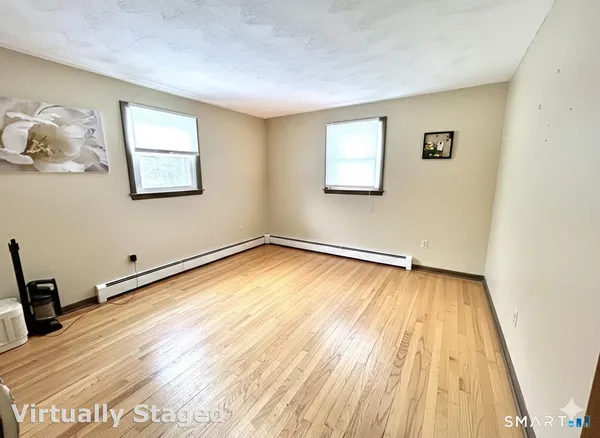 a view of a room with wooden floor and white walls