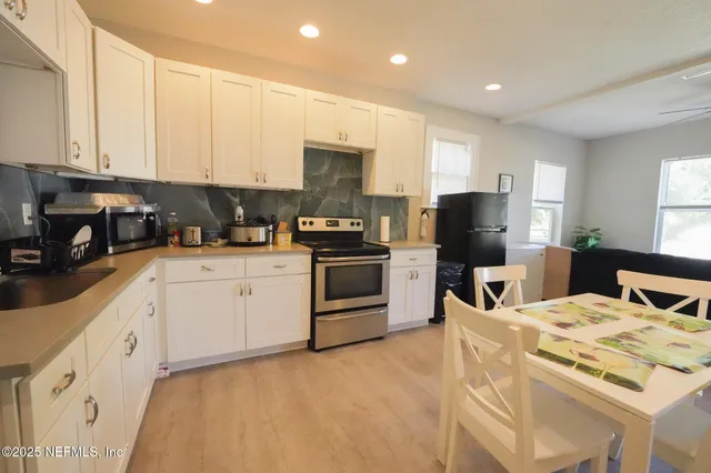 a kitchen with white cabinets and stainless steel appliances