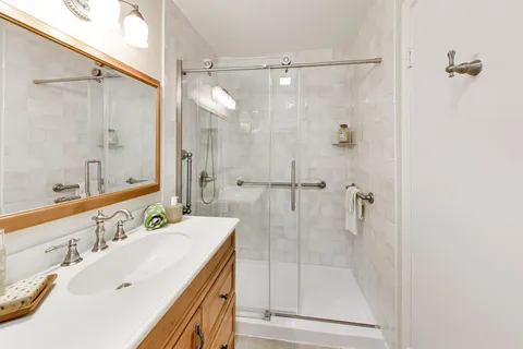 a bathroom with a tub sink shower and mirror