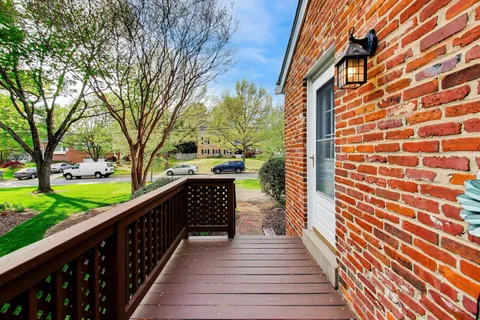 a balcony with wooden floor and trees