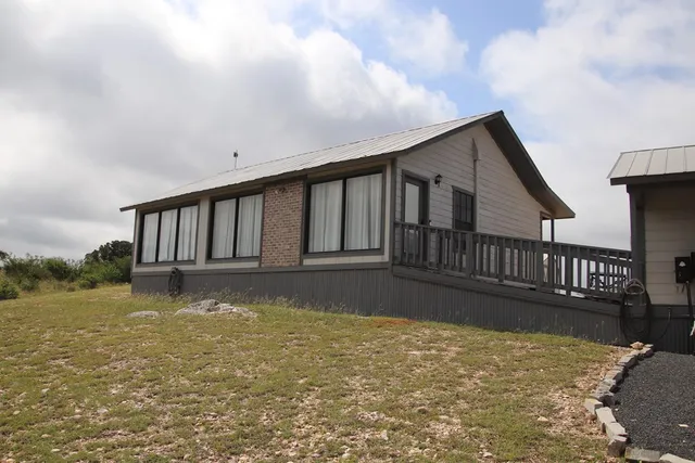 a front view of a house with large trees