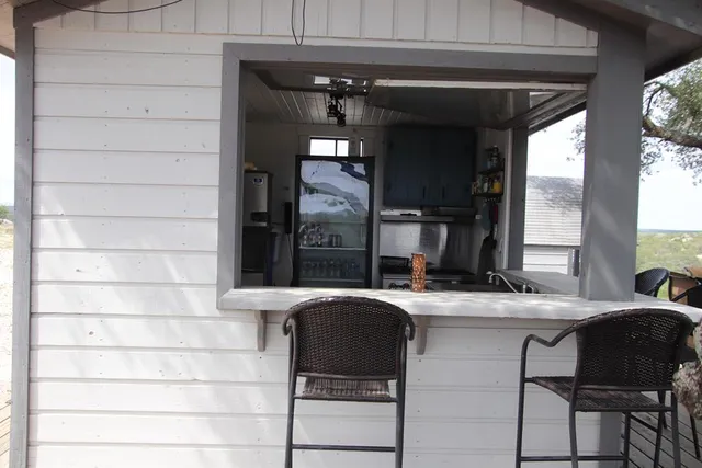 a view of a patio with table and chairs and floor to ceiling window wooden floor and fence