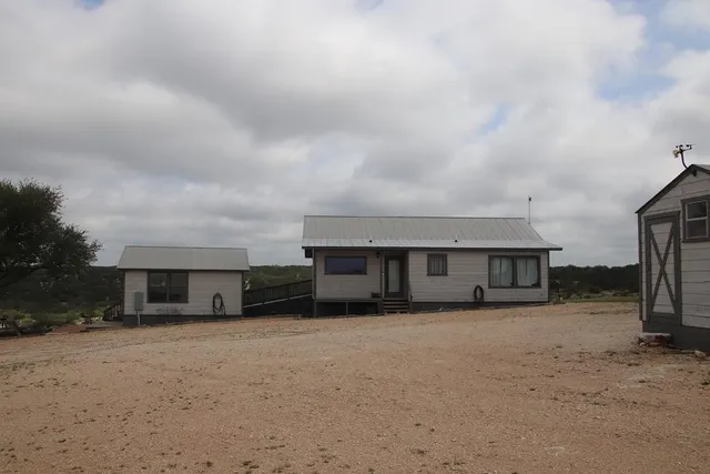 a backyard of a house with a yard and outdoor seating