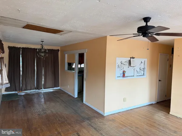 a view of a hallway with a wooden floor and a ceiling fan