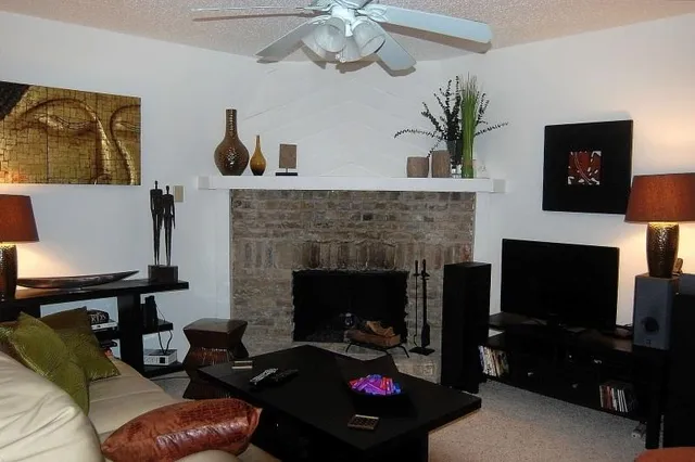 a living room with furniture a fireplace and a flat screen tv