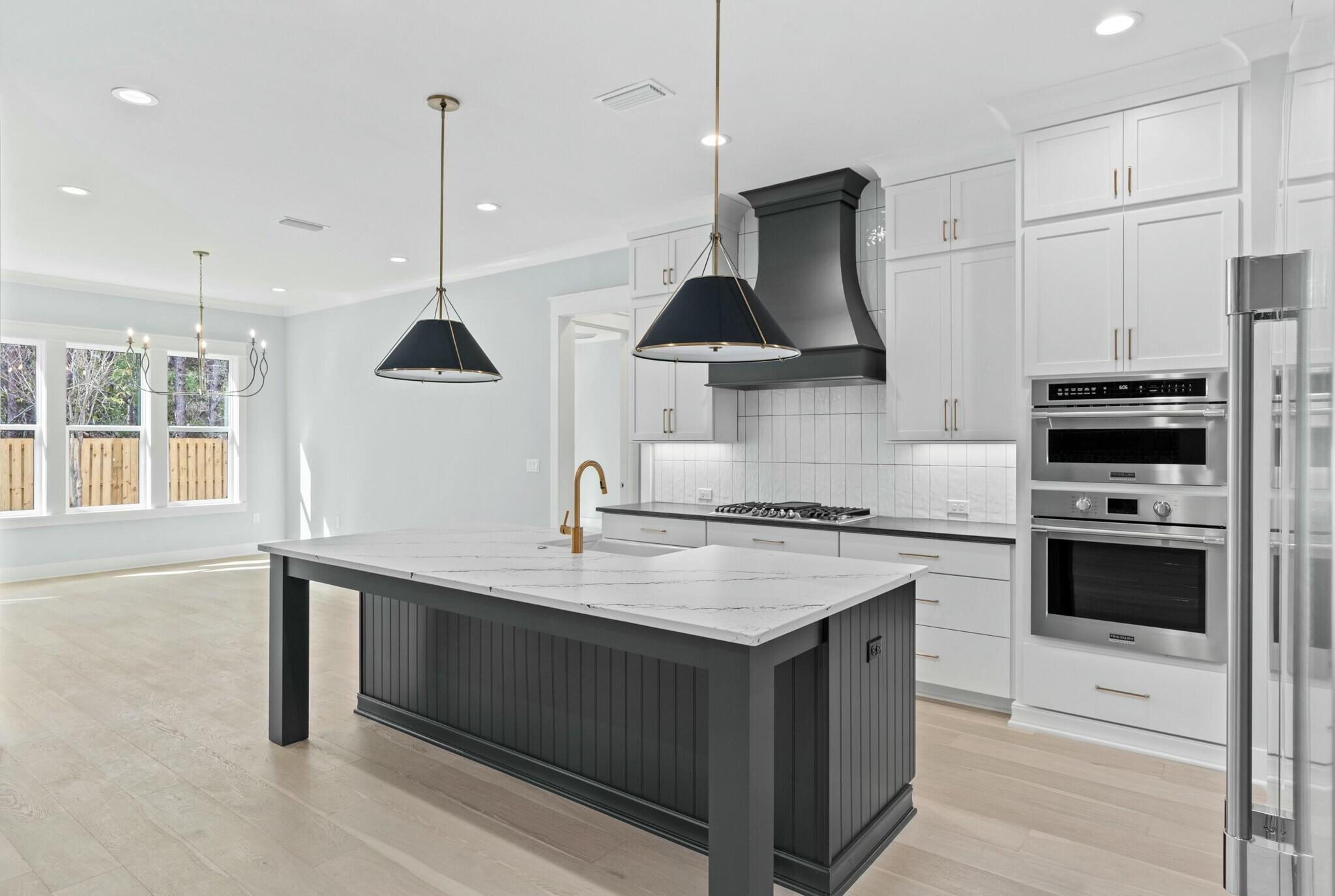 73 Sparkle Street Freeport, FL 32439 - Photo 7 of 27 a kitchen with stainless steel appliances a stove a sink a center island and cabinets