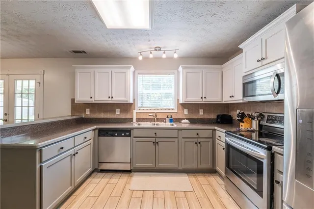 a kitchen with a sink stove cabinets and window