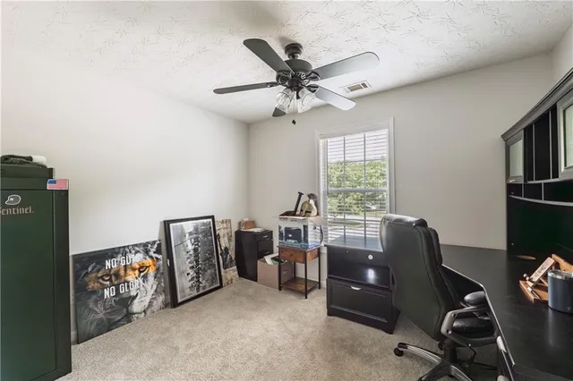 a view of a workspace with furniture and a window