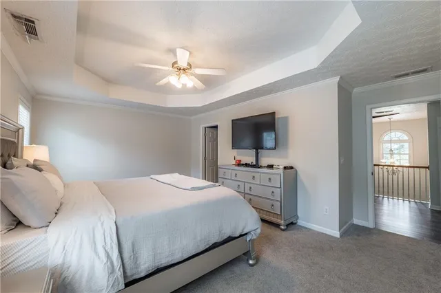 a bedroom with a large bed and a flat tv screen on dresser