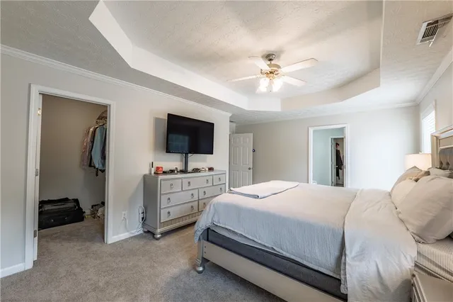 a bedroom with a bed and a flat tv screen on dresser