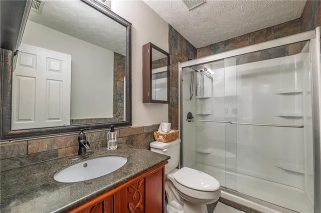 a bathroom with a sink a toilet and shower