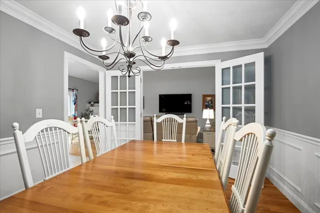 a view of a dining room with furniture a chandelier and wooden floor