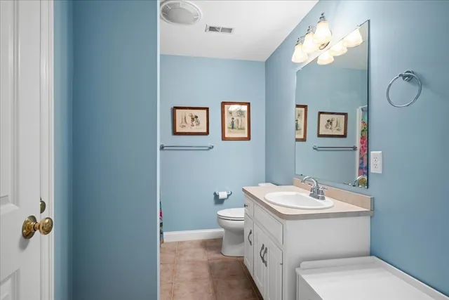 a bathroom with a toilet sink and mirror