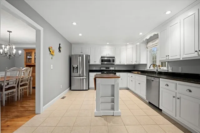 a kitchen with stainless steel appliances granite countertop a refrigerator and a stove top oven