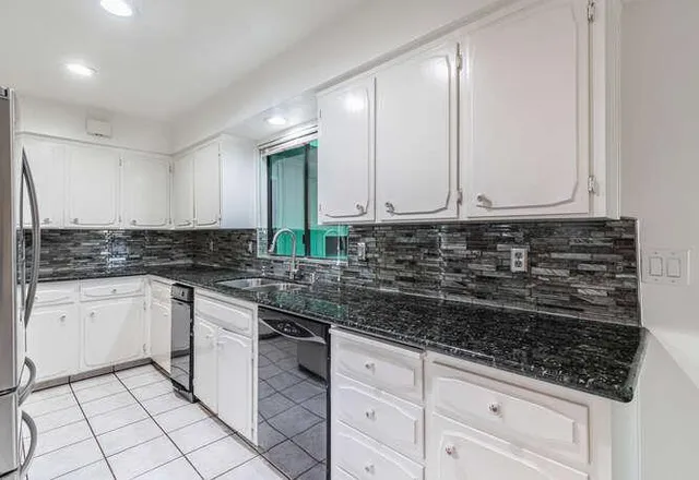 a kitchen with stainless steel appliances granite countertop a sink and a stove