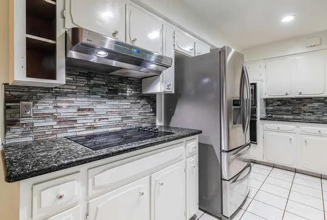a kitchen with stainless steel appliances granite countertop a refrigerator and a sink