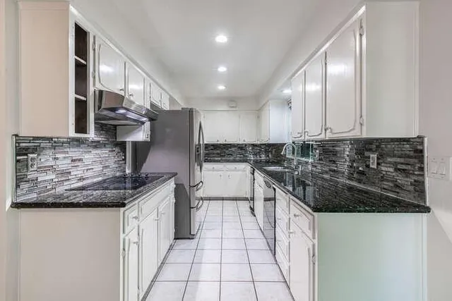 a kitchen with stainless steel appliances granite countertop a sink stove and cabinets