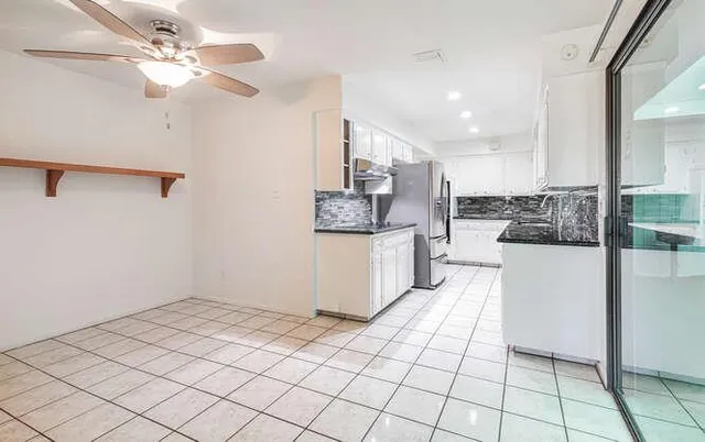a kitchen with stainless steel appliances kitchen island granite countertop a refrigerator and a stove