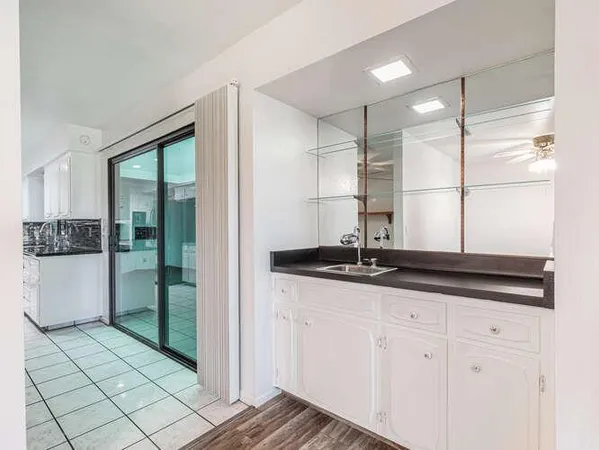 a kitchen with granite countertop white cabinets and stainless steel appliances