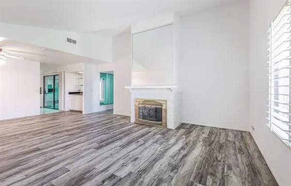 wooden floor fireplace and windows in an empty room