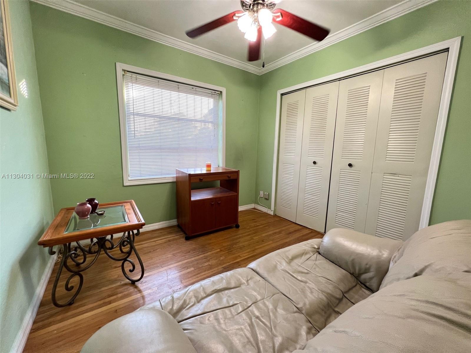 231 West 43rd Street Hialeah, FL 33012 - Photo 9 of 14 a bedroom with a bed and a chandelier