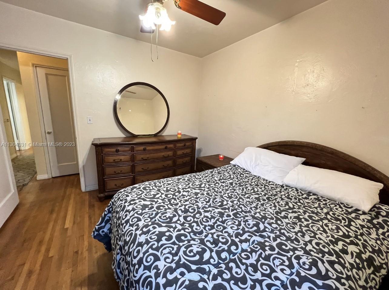 231 West 43rd Street Hialeah, FL 33012 - Photo 10 of 14 a bedroom with a bed and a chandelier