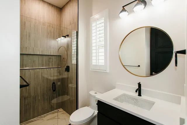 a bathroom with a sink a toilet and shower