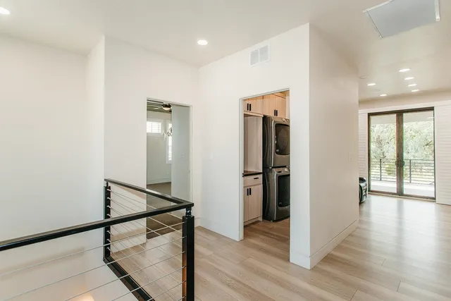 a view of a hallway with wooden floor and staircase