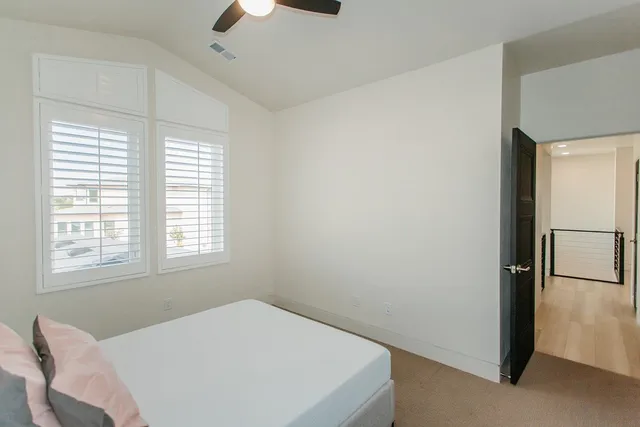 a bedroom with a bed and a chandelier fan