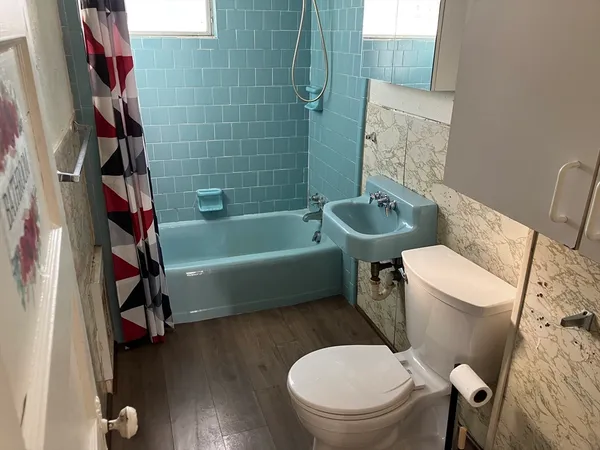 a white toilet sitting next to a bath tub and a shower