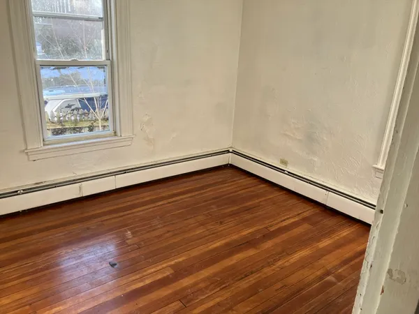 a view of a room with wooden floor and window