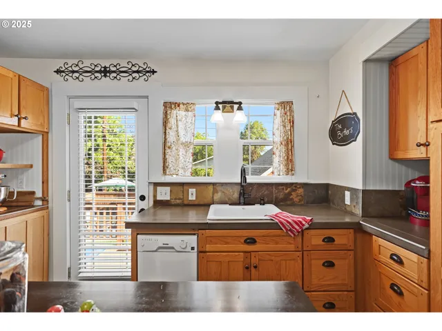 a kitchen with granite countertop a sink window and cabinets