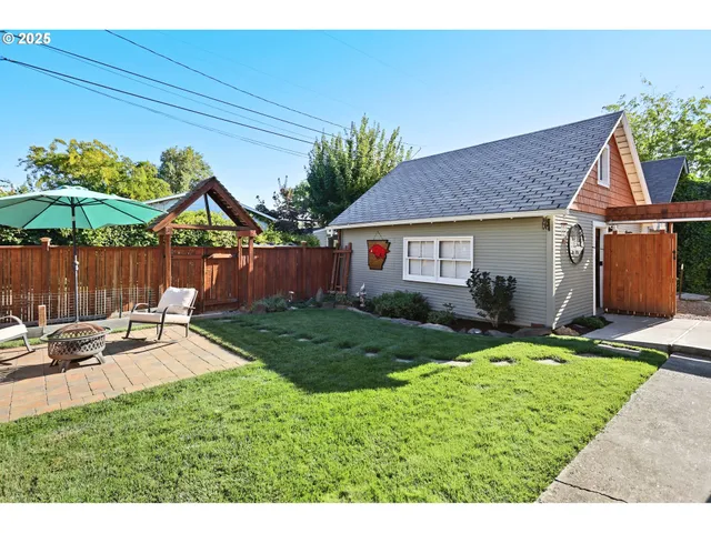 a backyard of a house with table and chairs
