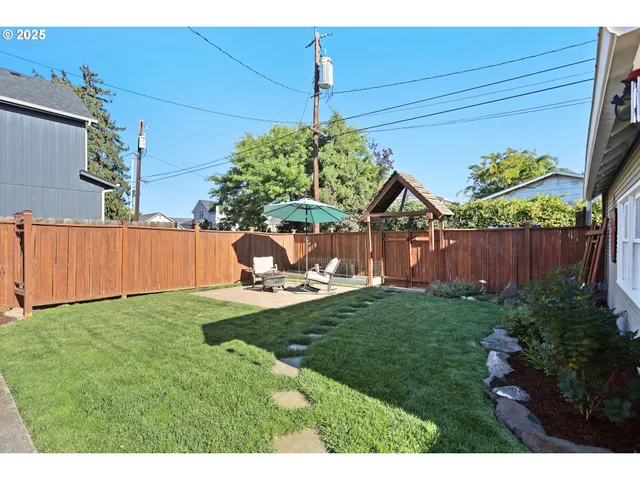 a view of a backyard with wooden fence