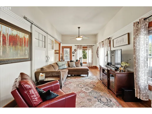a living room with furniture a large window and a flat screen tv